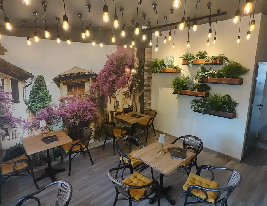 Sala z różową bugenwillą, zielonymi doniczkami i światełkami